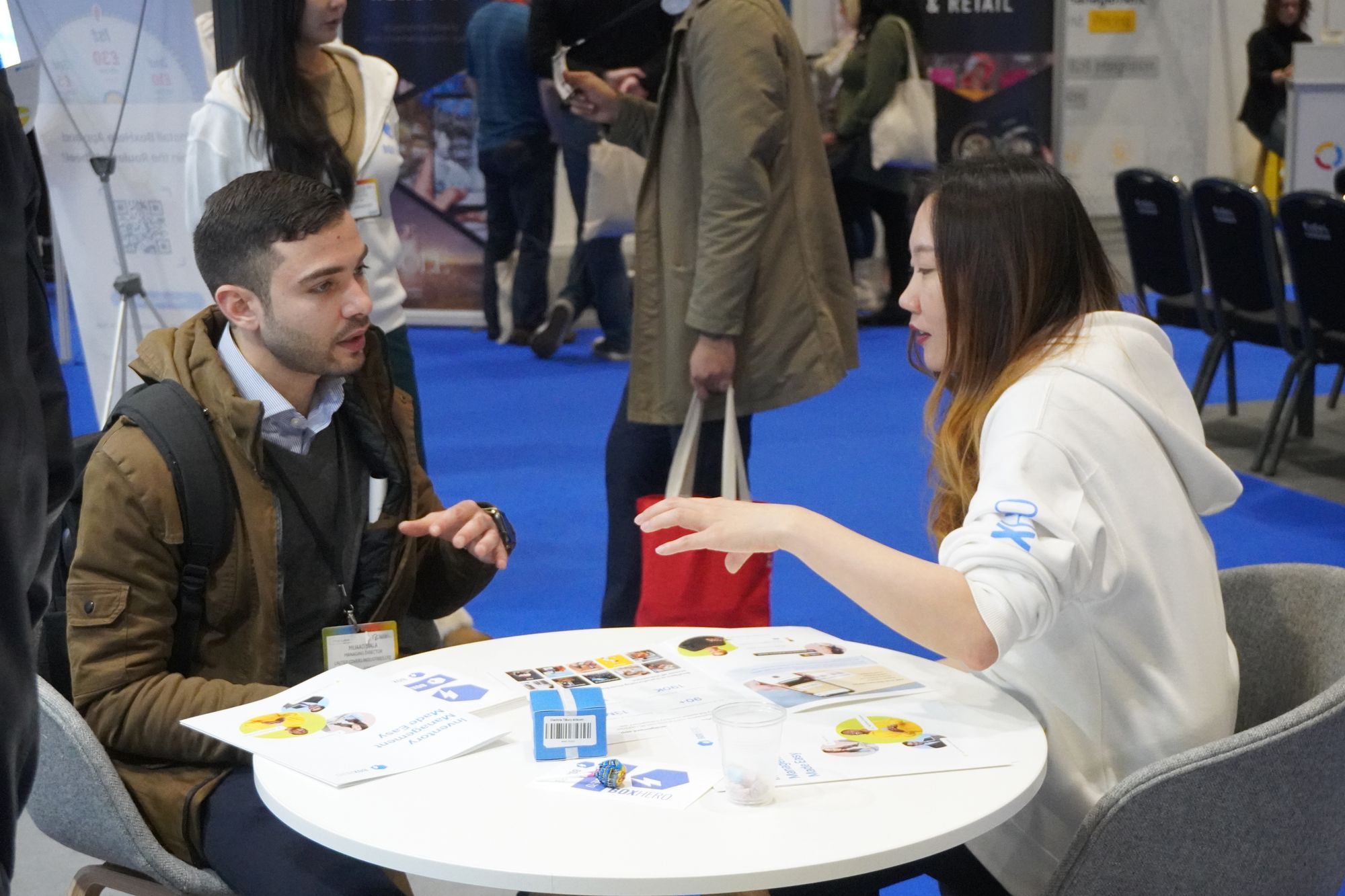 A team member sitting at a table, explaining BoxHero to the booth visitor