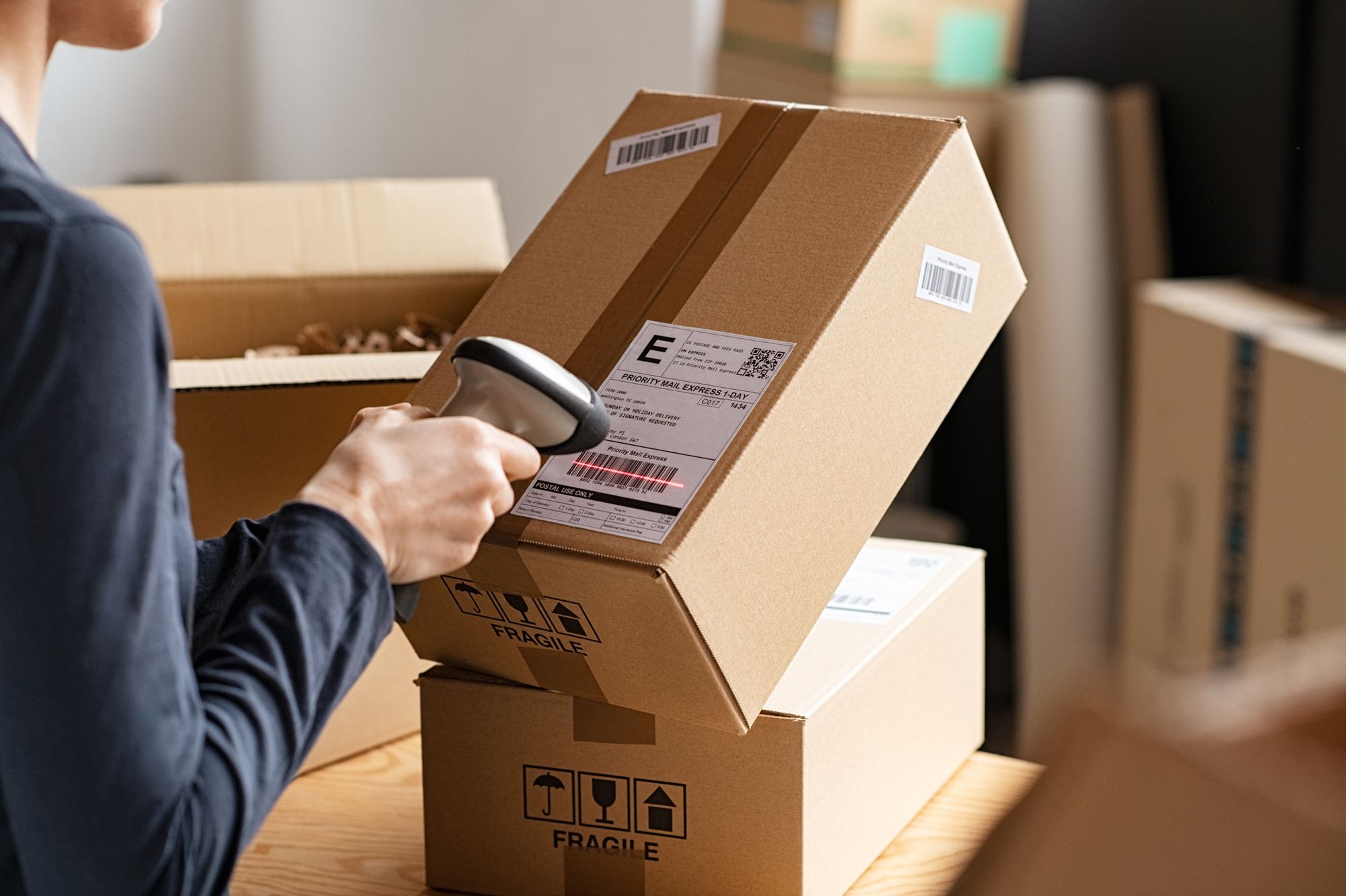 An employee scanning a barcode on a box using a barcode scanner