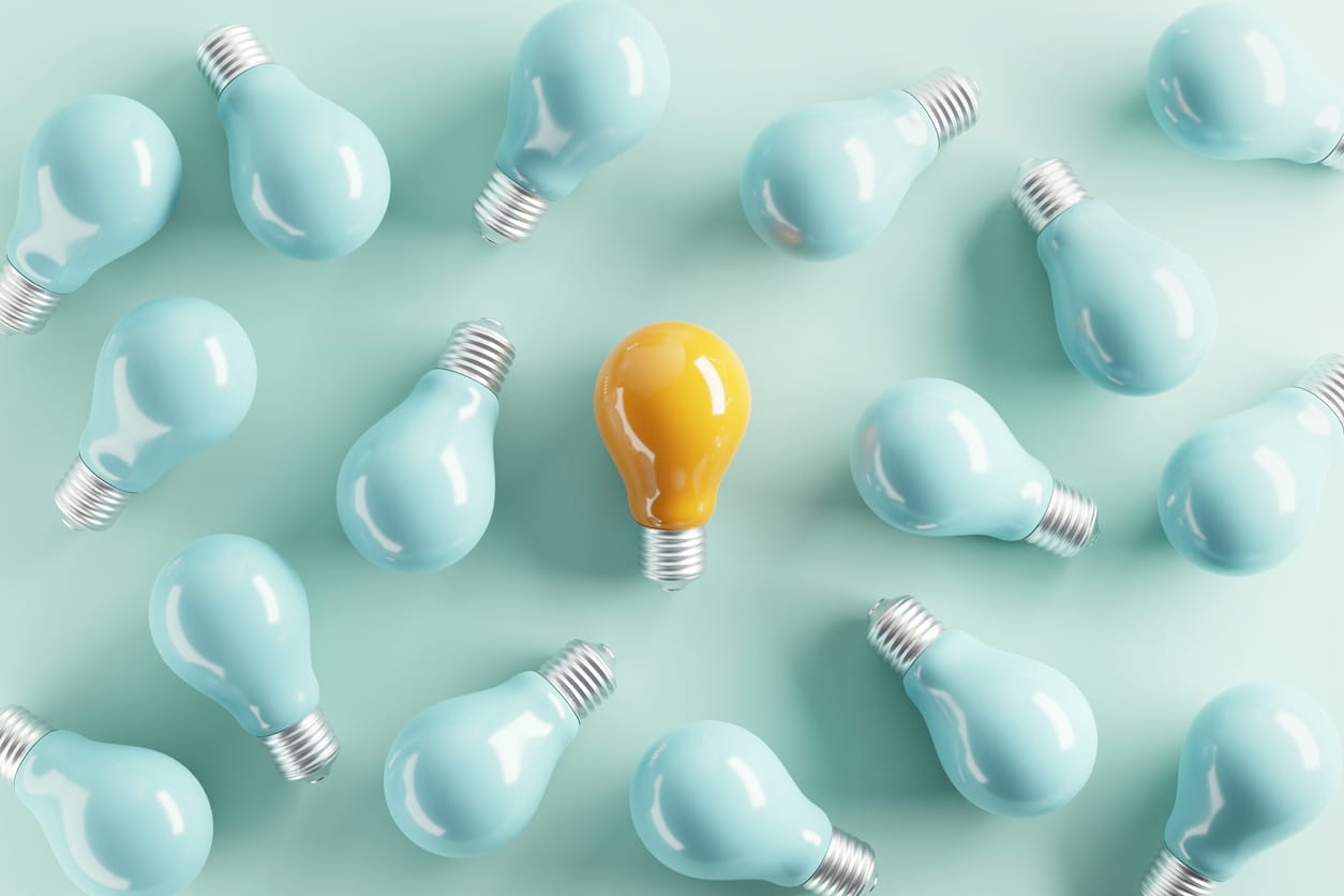 Minimal idea of yellow light bulb surrounded with blue bulbs on pastel background. 3d rendering. 