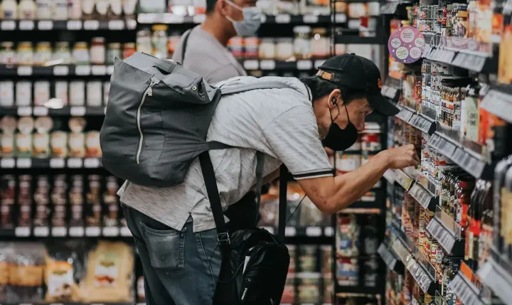 2 men shopping at a supermarket, looking at labels