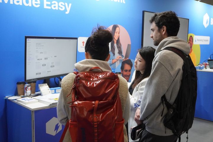 A female team member demonstrating BoxHero's features to booth visitors