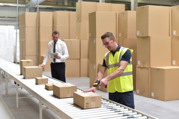 A man shipping a product in a warehouse.